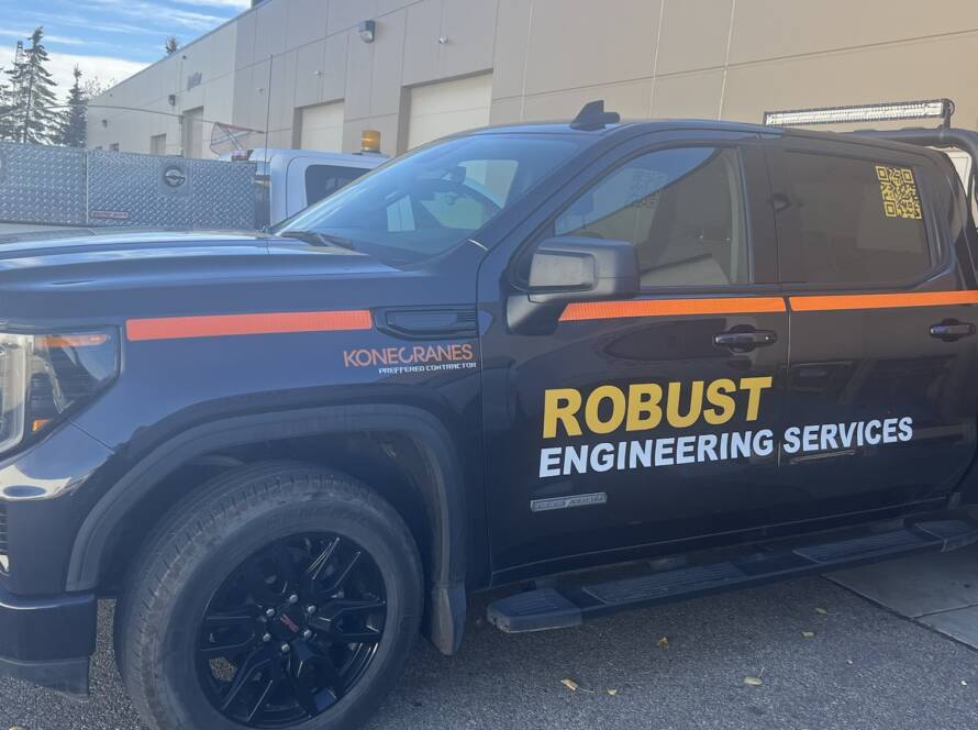 Black GMC Sierra crew cab wrapped in Robust Engineering Services orange-and-black branding, with a Konecranes Preferred Contractor badge and a roof-mounted LED light bar
